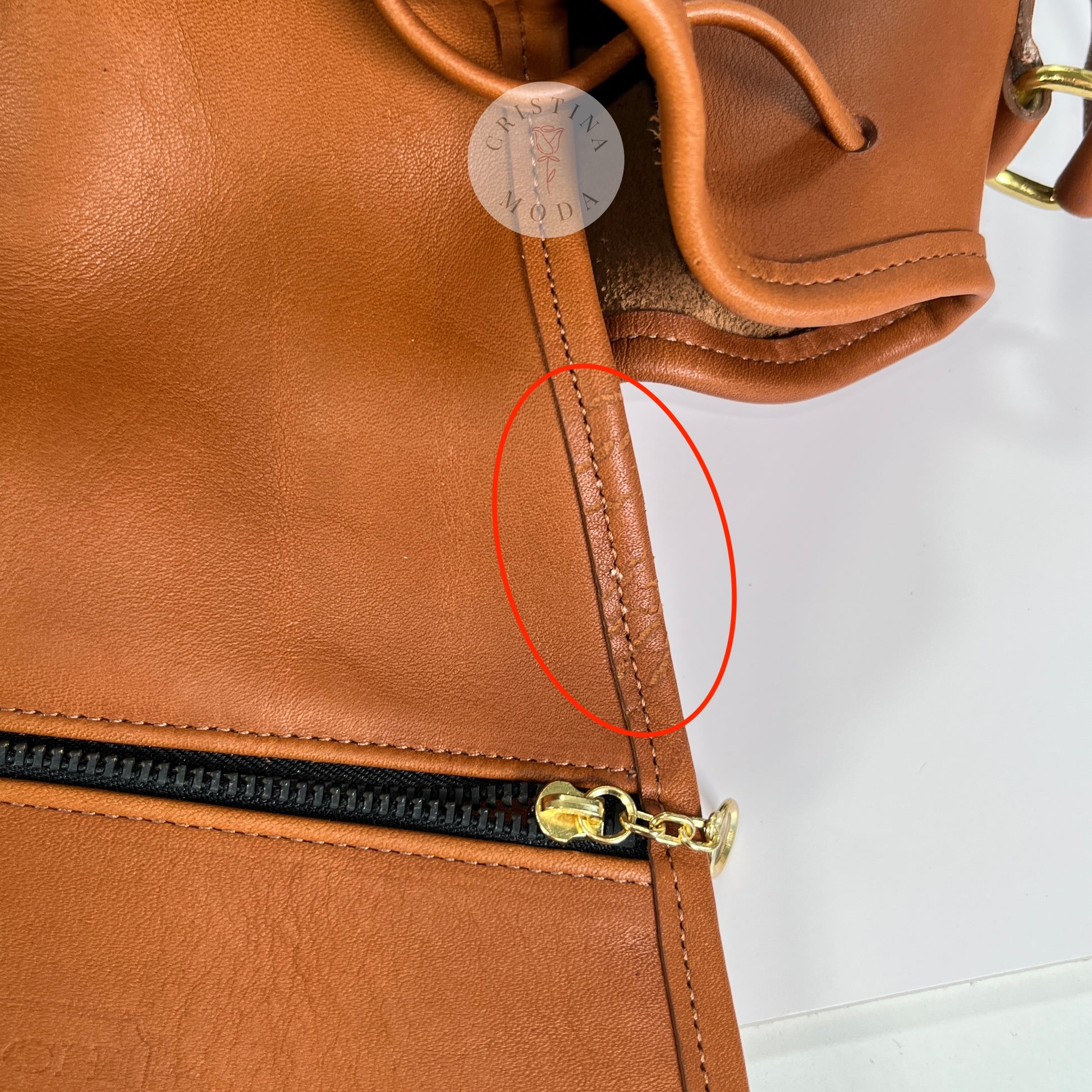 Photo showing superficial scratches to the leather along the side of the inside hanging pocket area. 