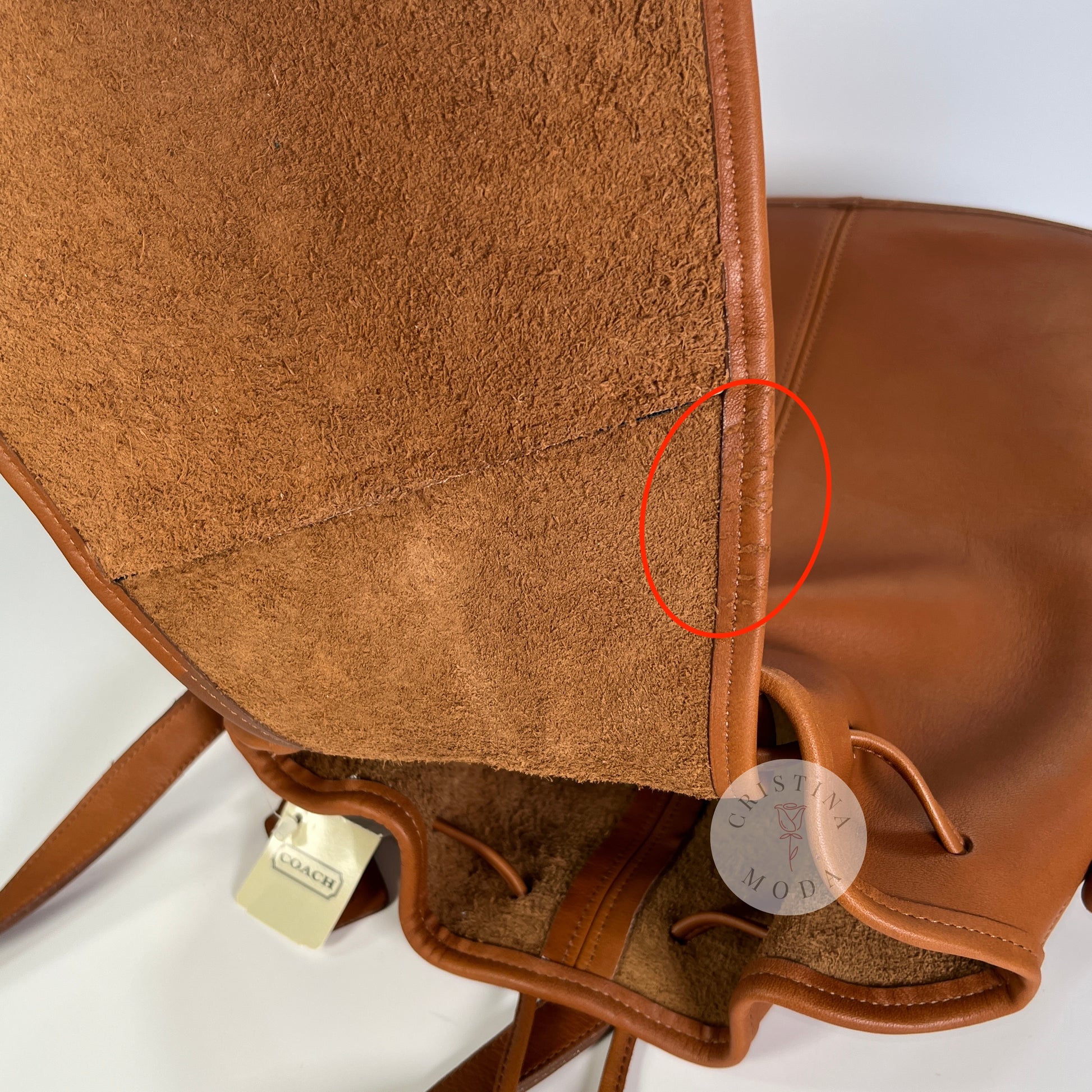 Photo showing superficial scratches to the leather along the side of the inside hanging pocket area. 