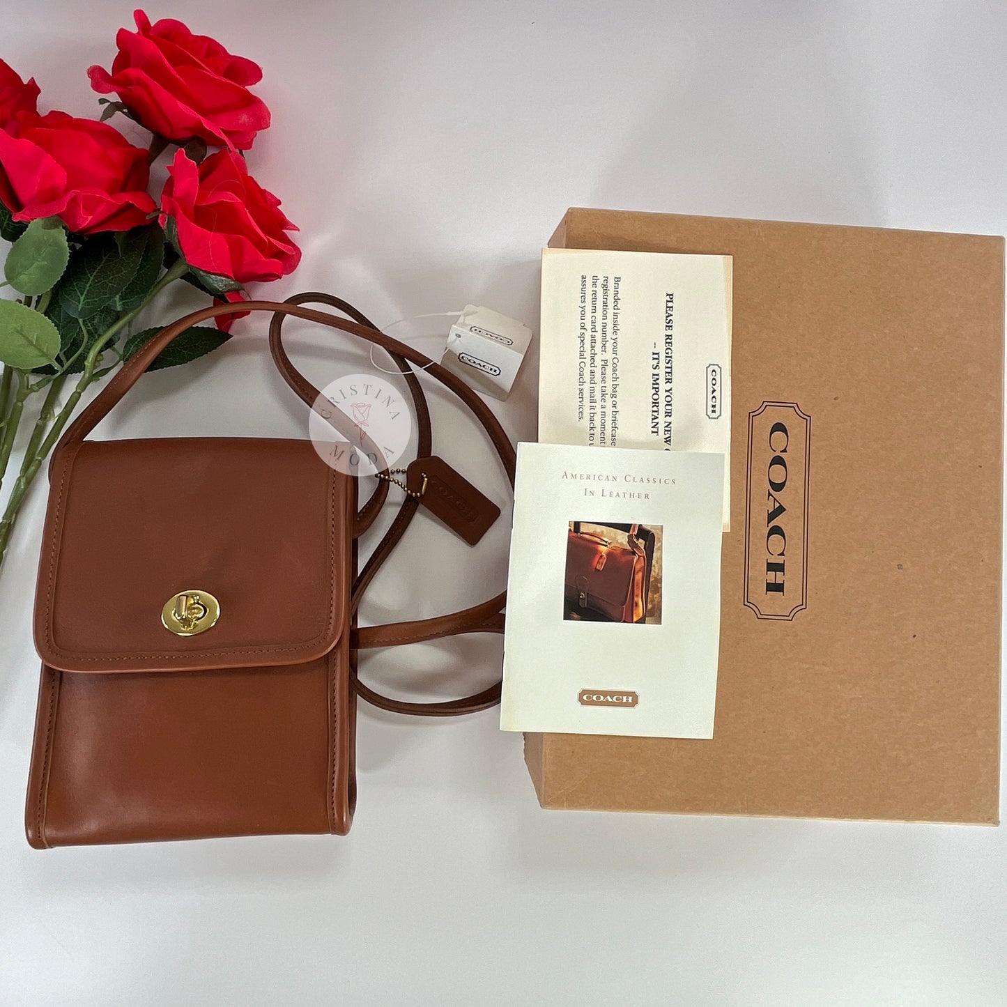 Vintage Coach Scooter Bag in British Tan, view of front of bag, box, and paperwork laying next to 4 roses