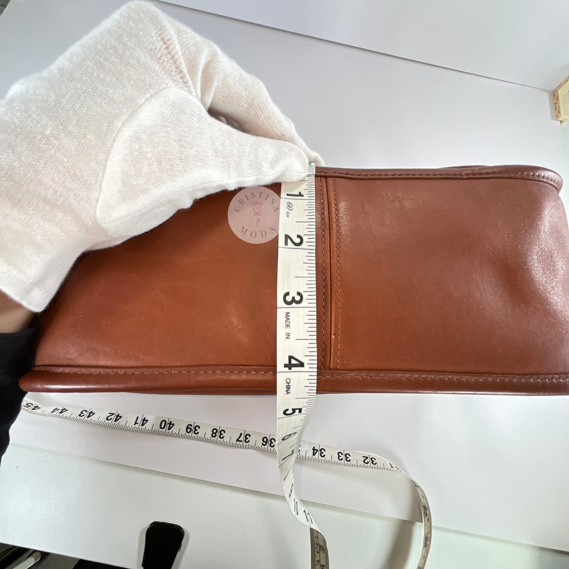 View of measuring tape showing depth measurement of vintage coach Patricia's Legacy Bag in British Tan