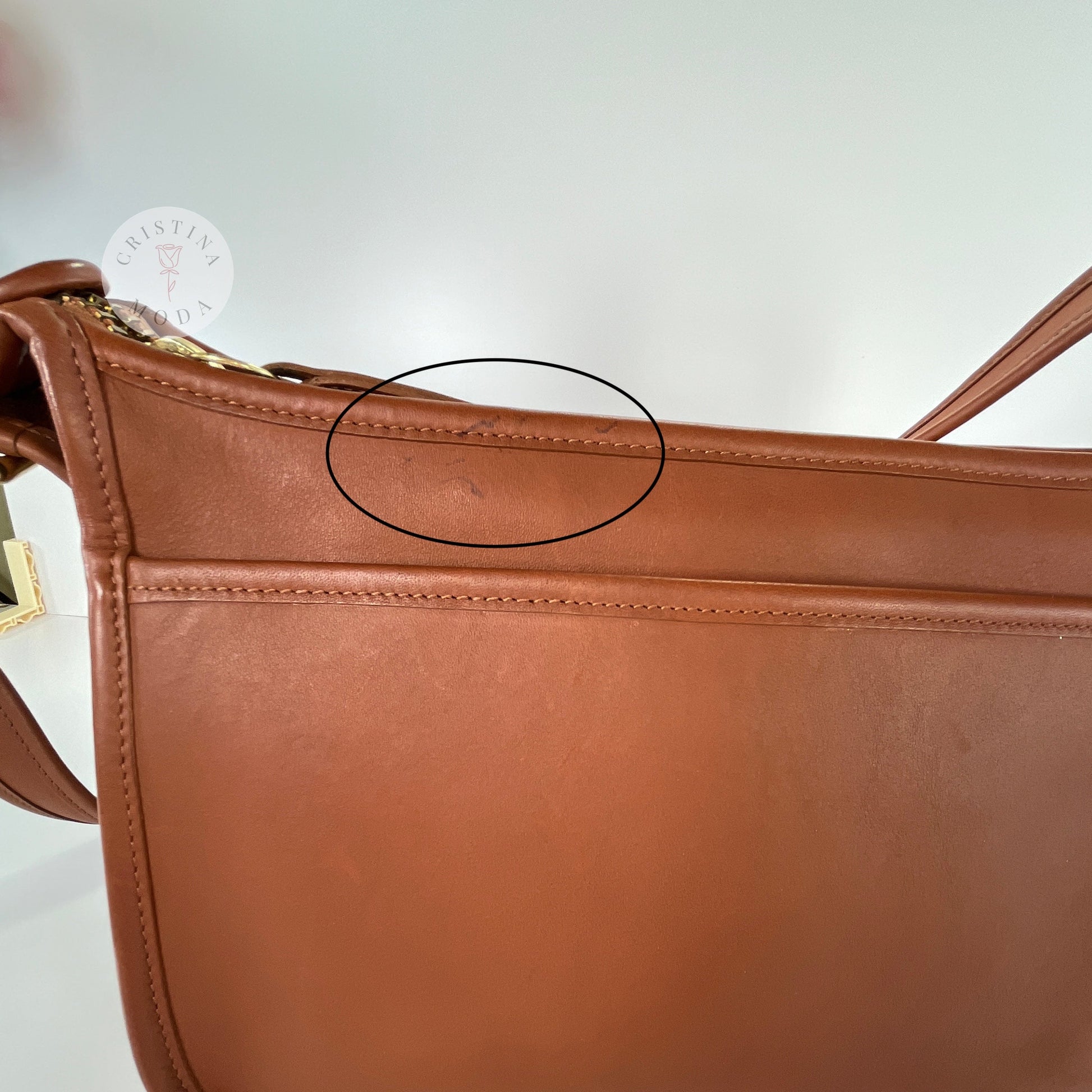 Close up showing circled area with pen marks on area that sits underneath front flap area of vintage coach Patricia's Legacy Bag in British Tan