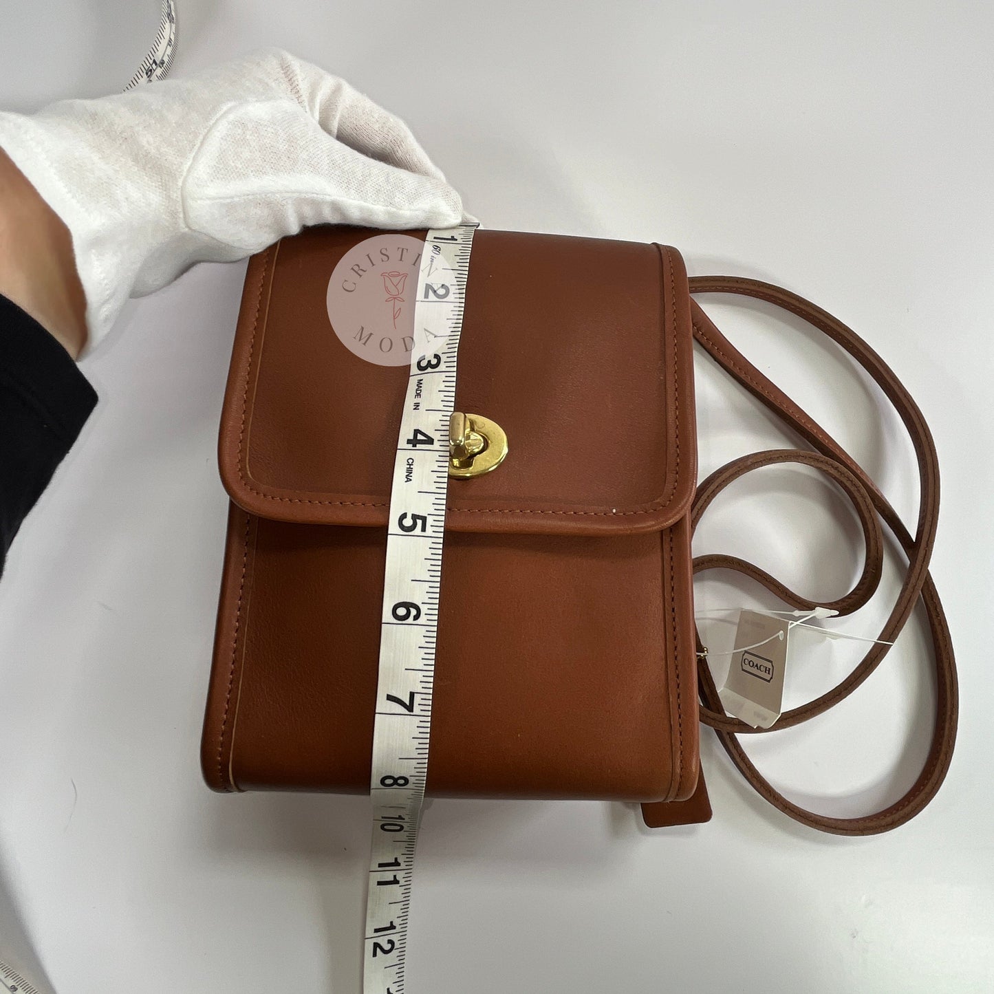 View of British tan vintage Coach Scooter Bag with tape measure showing top down view of height measurement of front of bag
