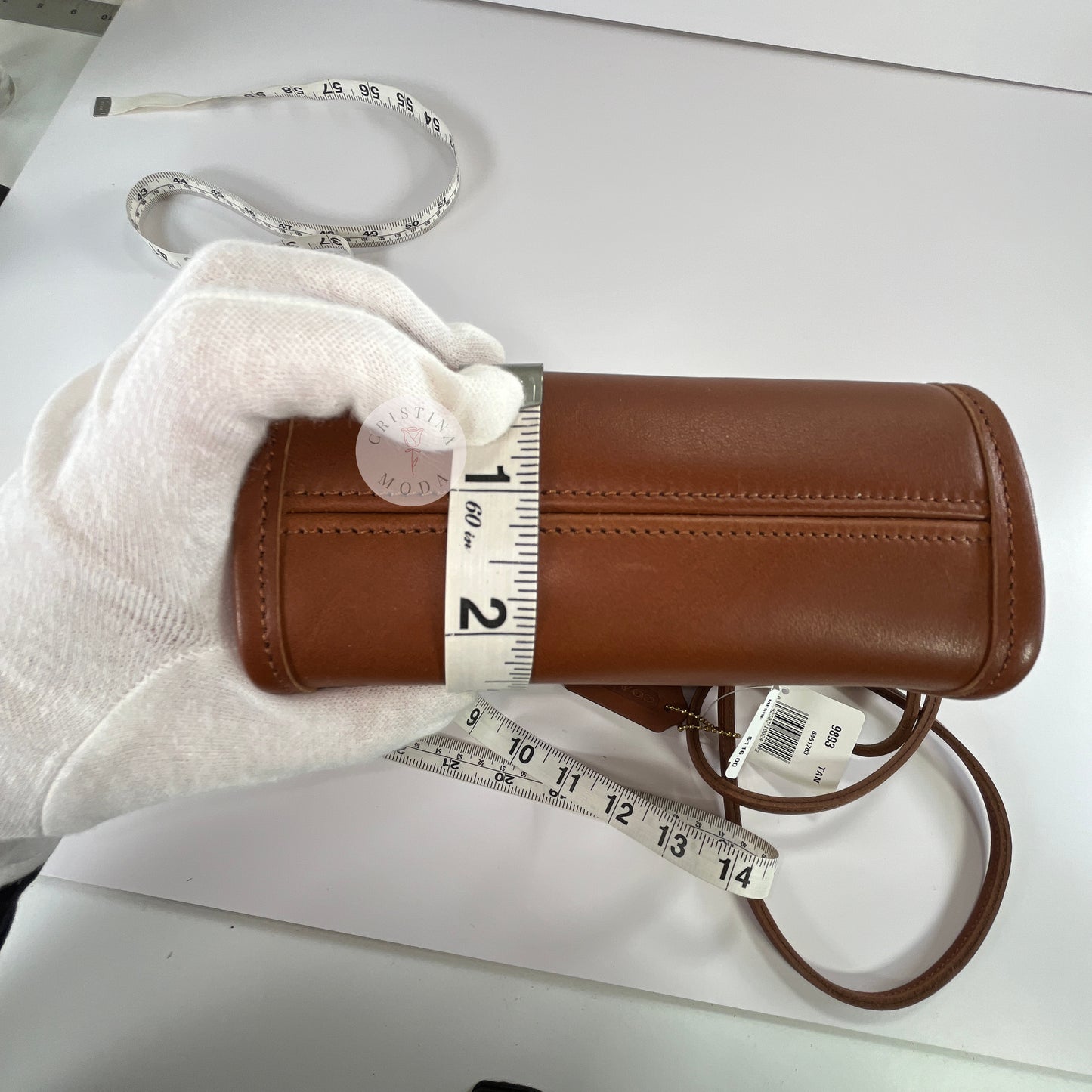 View of British tan vintage Coach Scooter Bag with tape measure showing bottom depth measurement