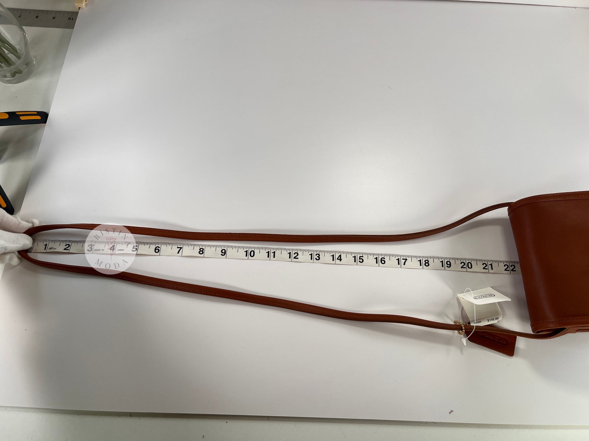 View of British tan vintage Coach Scooter Bag with tape measure showing strap drop measurement