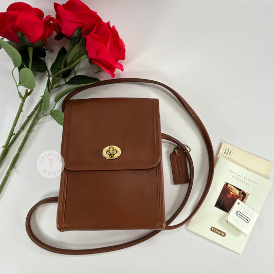 Vintage Coach Scooter bag in British Tan leather, front view laying next to roses