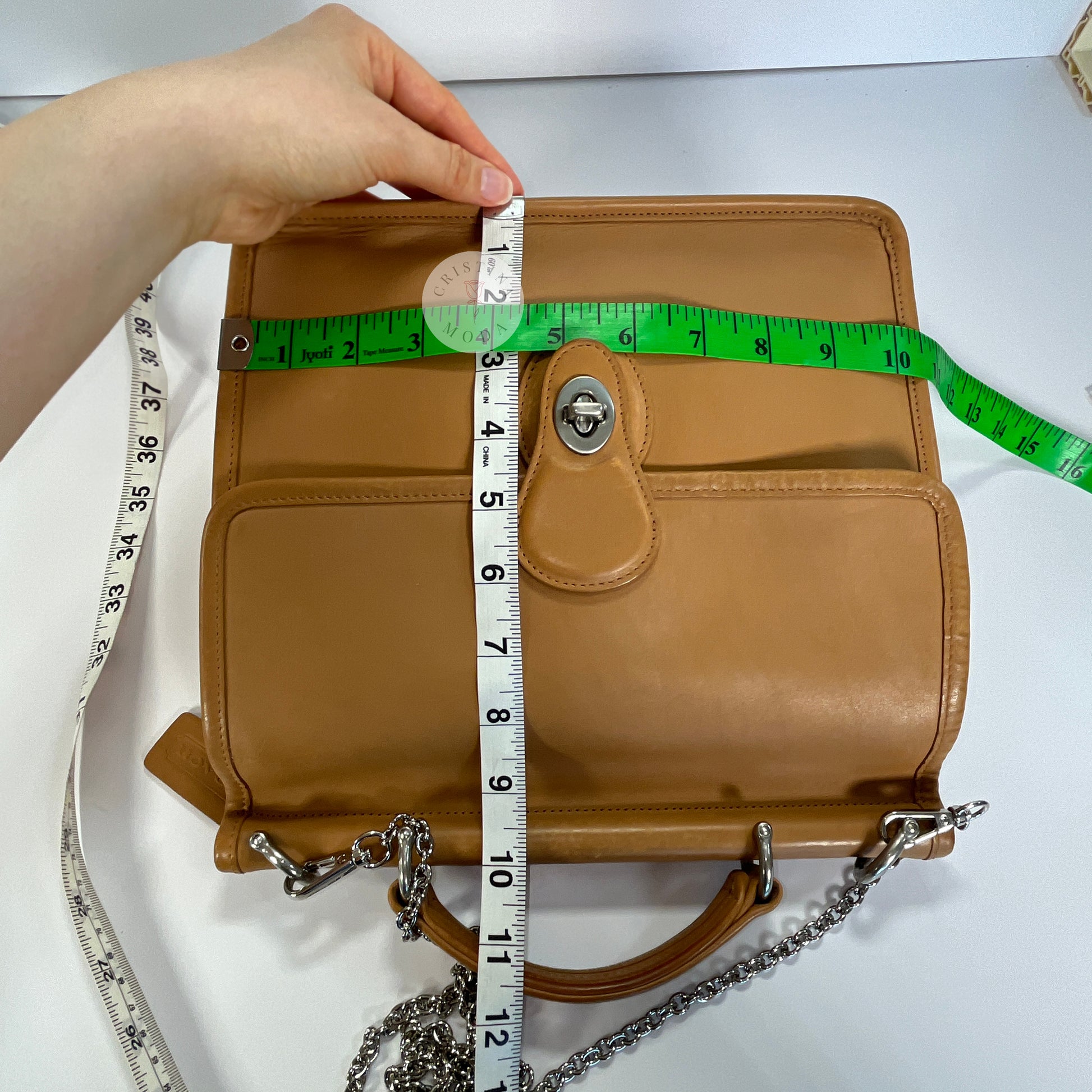 image showing 2 tape measures measuring the front of the bag, length by width- the measurements are approximately 10.5 inches by 10 inches