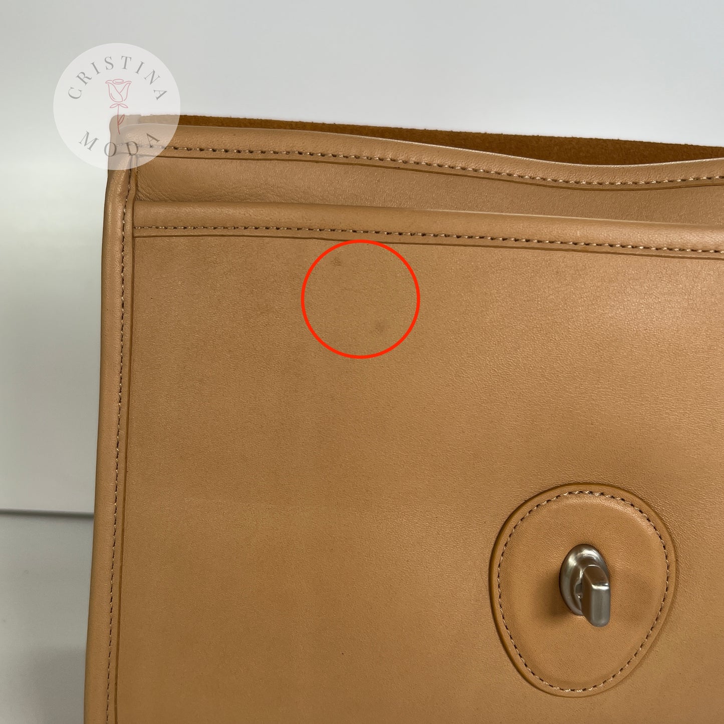 vintage coach willis bag in Camel colored leather- close up photo showing two faint marks on the section under the front flap of the bag