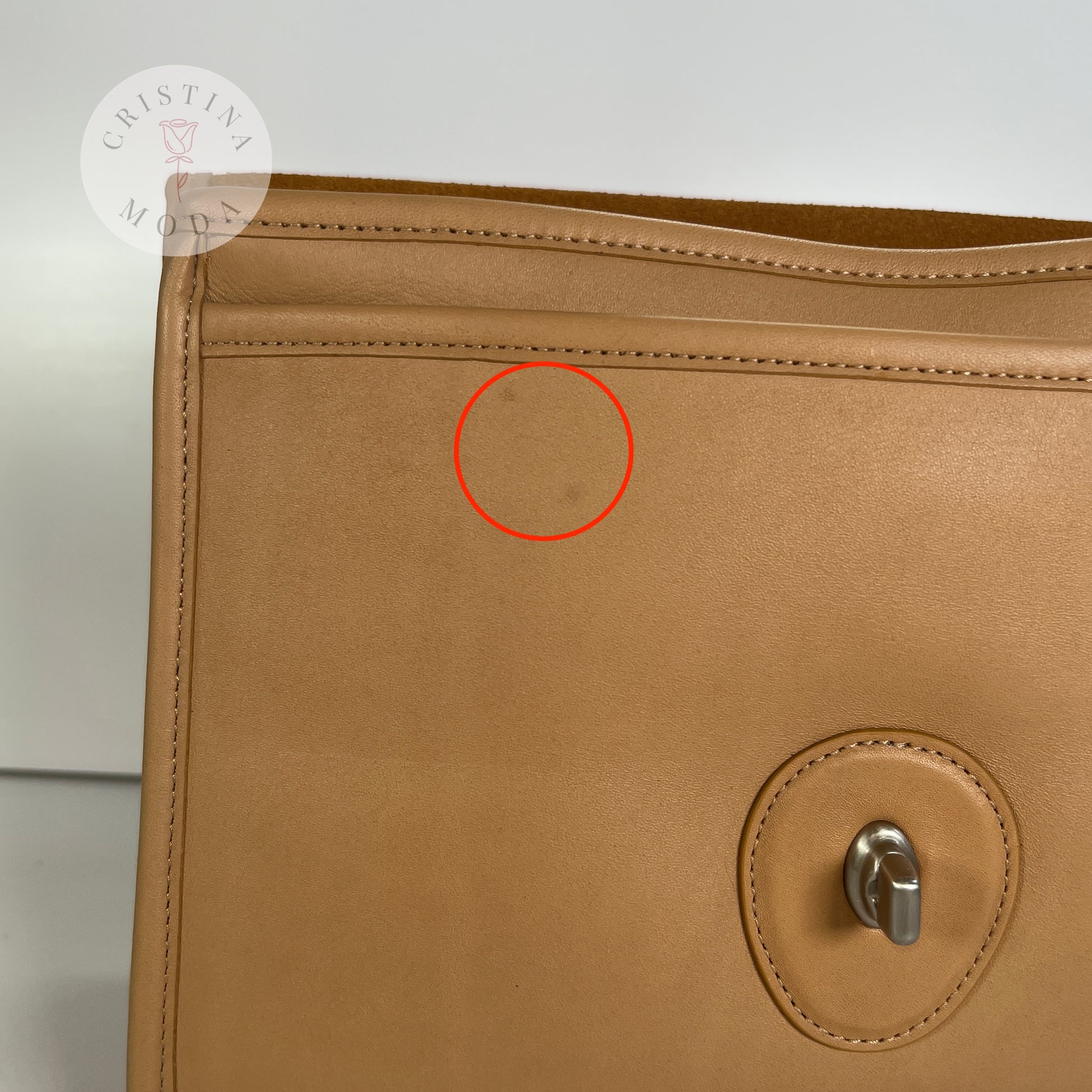 vintage coach willis bag in Camel colored leather- close up photo showing two faint marks on the section under the front flap of the bag