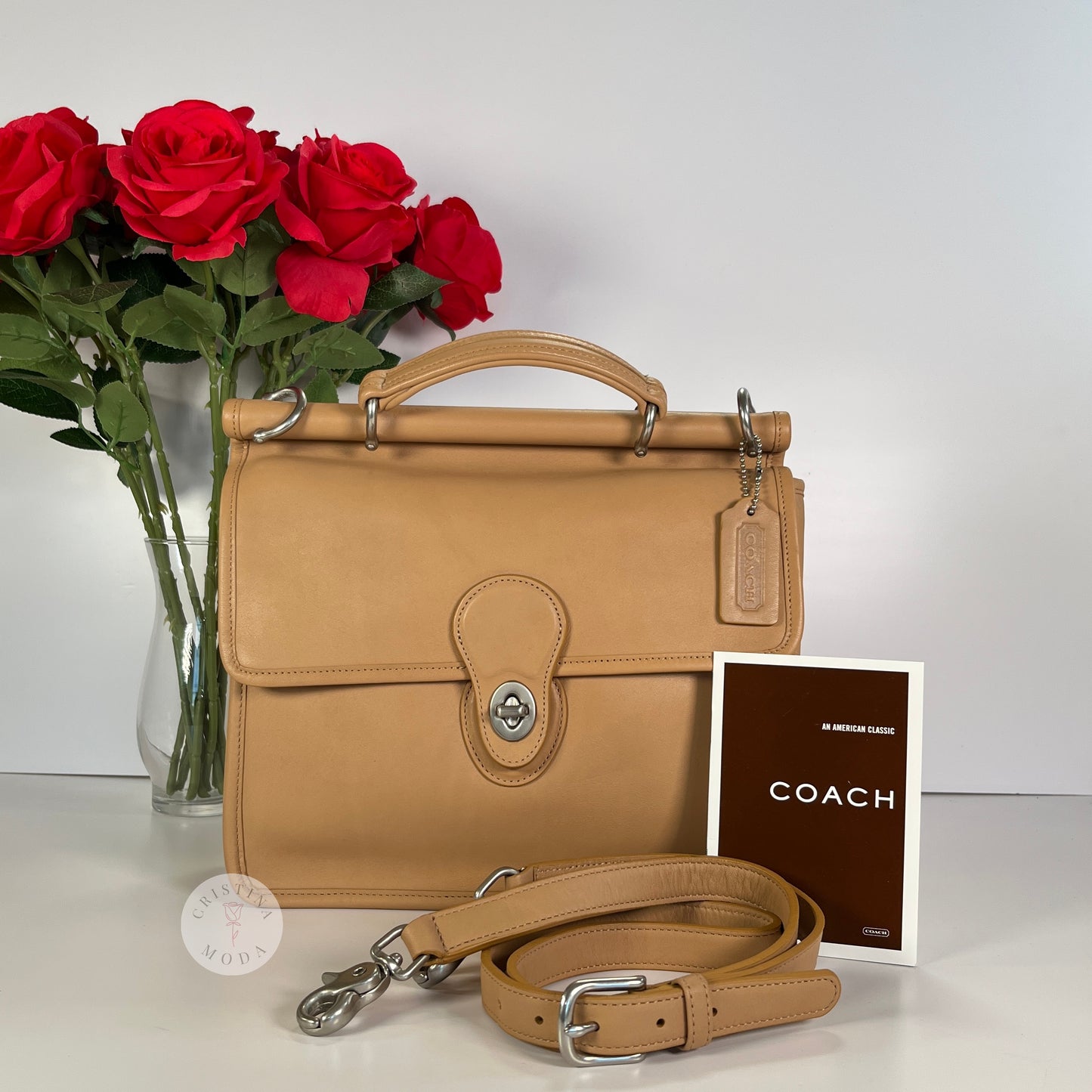 vintage coach willis bag in Camel colored leather- cover photo showing front of bag in front of a bouquet of roses